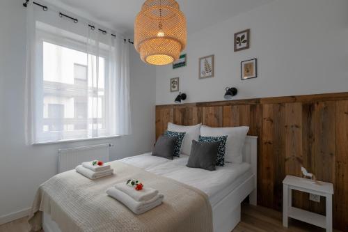 - une chambre avec un lit et 2 serviettes dans l'établissement Apartamenty NCNK Osiedle Bursztynowe w Jantarze, à Jantar