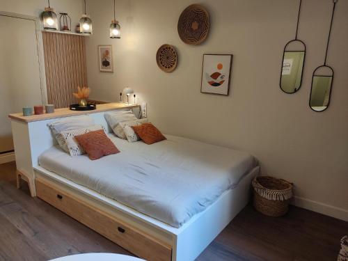 um quarto com uma cama branca com almofadas em Ravissant Studio à Pézenas em Pézenas