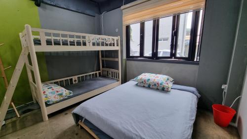 a small room with a bunk bed and a ladder at Jungle guesthouse in Danyang