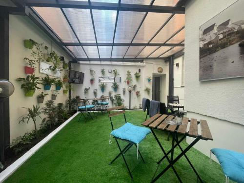 a room with green grass and tables and chairs at Hotel Story in Sarajevo
