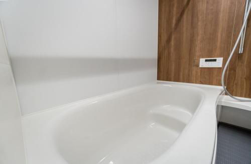 a bathroom with a white tub next to a sink at HANASTAY花渓居 · 澄（KIYOSI) in Osaka