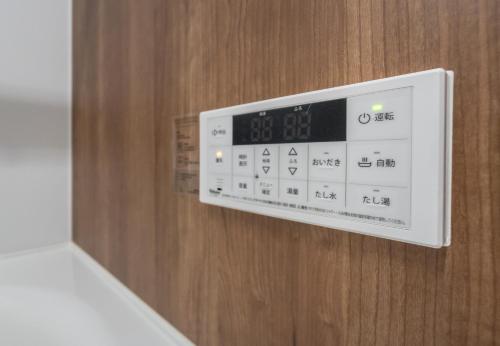 a clock is attached to a wooden door at HANASTAY花渓居 · 澄（KIYOSI) in Osaka