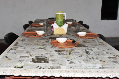 a table with a table cloth with bowls and plates on it at Corbett Bhavesh home Stay in Jhirna