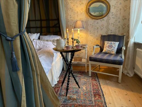 a bedroom with a bed and a table and a chair at Nääs Slott in Floda