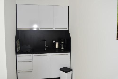 eine Küche mit weißen Schränken und einer schwarzen Arbeitsplatte in der Unterkunft Villa Dalija in Biograd na Moru