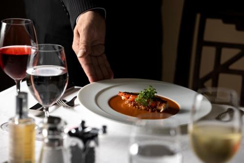 a person sitting at a table with a plate of food at Hamilton Ureshino in Ureshino