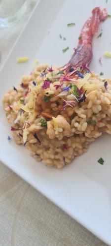 a white plate with rice and vegetables on it at Le Castella B&B Restaurant in Le Castella