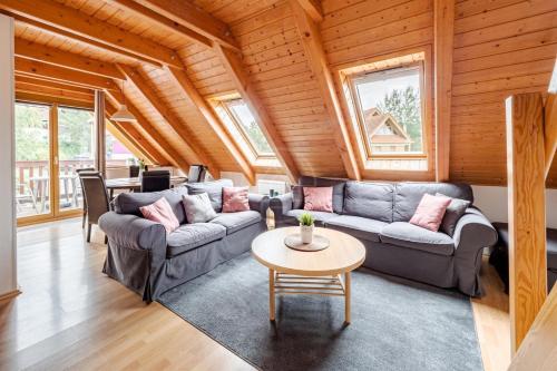 a living room with two couches and a table at Riviera Lipno 503 - 15 in Lipno nad Vltavou