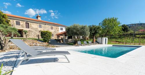 a villa with a swimming pool in front of a house at Casa do testado in Ponte de Lima