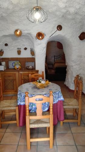 comedor con mesa y algunas sillas en Casa Cueva Sierra Nevada - Monachil, en Monachil