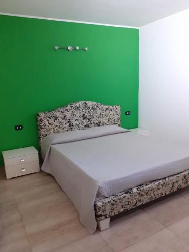 um quarto com uma cama grande e uma parede verde em Casa Dylan em Cagliari