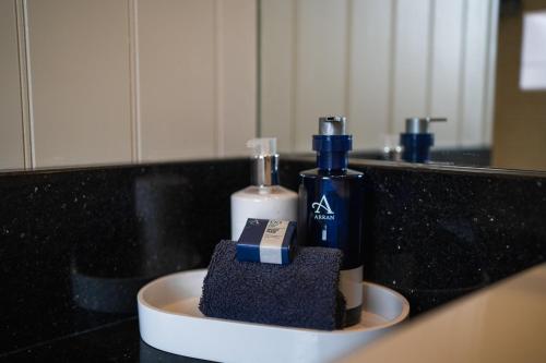 a bathroom counter with two bottles of soap and a sink at Inver Lodge in Lochinver