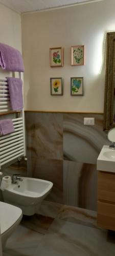 bagno con lavandino, servizi igienici e specchio di La casa di Carmen a Melfi