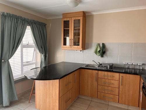 a kitchen with a black counter top and a sink at Stay @ 24 Malachite in Knysna