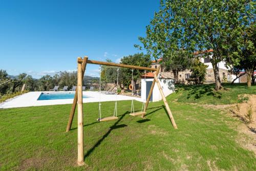 - une balançoire dans une cour à côté d'une piscine dans l'établissement Casa do testado, à Ponte de Lima