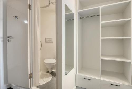 a bathroom with a toilet and a glass closet at Bright & Central Room in Luton, Sleeps 2 in Luton