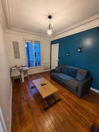 uma sala de estar com um sofá e uma mesa em Un appartement authentique à deux pas de Paris . em Saint-Mandé