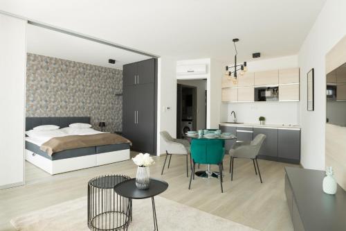 een slaapkamer en een woonkamer met een bed en een tafel bij Parizs Garden Apartments in Debrecen