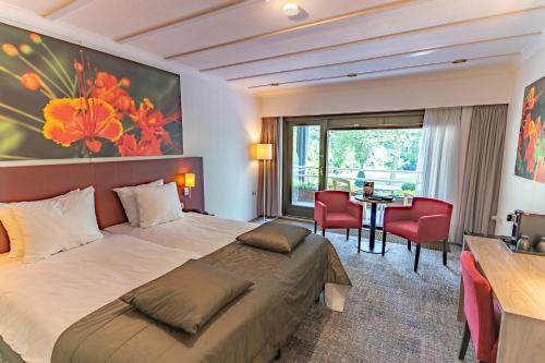 Habitación de hotel con cama, mesa y sillas en Hotel Hof van Gelre by Flow, en Lochem