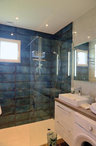 une salle de bain avec une douche en verre et un lavabo dans l'établissement Dousoleil, à La Teste-de-Buch