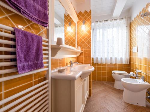 a bathroom with a sink and a toilet at La Marina Apartment with Patio & Parking in Fano