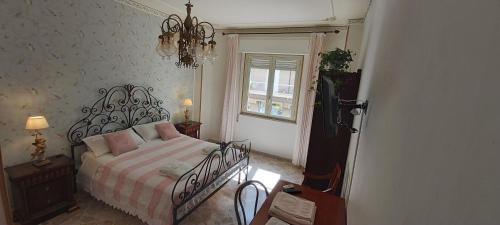 a bedroom with a bed and a window and a chandelier at Tilde B&B in Cefalù