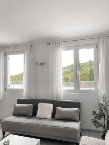 a living room with a couch and two windows at Afrodita in Nečujam