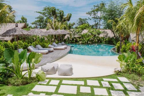 uma piscina com espreguiçadeiras e um resort em Gypsea Bali em Uluwatu