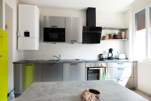 uma cozinha com utensílios de aço inoxidável e uma mesa em 55 m²/ Chez LÔrette/ 250m LAKE/ PRIVATE PARKING em Annecy