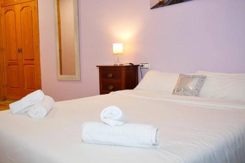 um quarto com duas toalhas brancas numa cama em Castaños apartment with AC em Alicante
