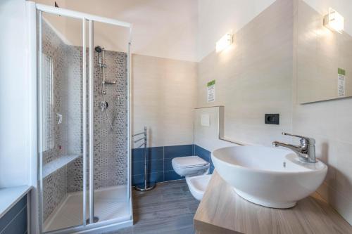 a bathroom with a sink and a shower and a toilet at Ca Cia - Yellow Flat Gardone in Gardone Riviera
