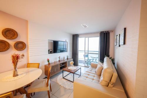 uma sala de estar com um sofá e uma mesa em Modern Beachfront Apartment w. Magnificent Seaview em Fortaleza