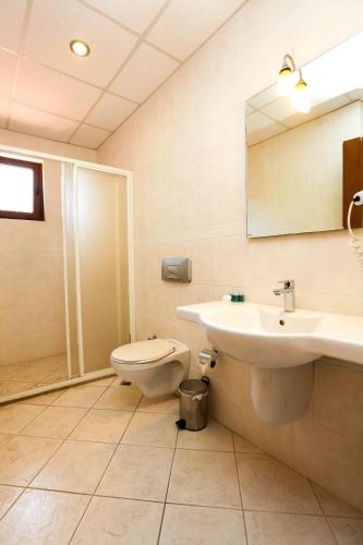 a bathroom with a sink and a toilet and a mirror at Gocek Unlu Hotel in Göcek