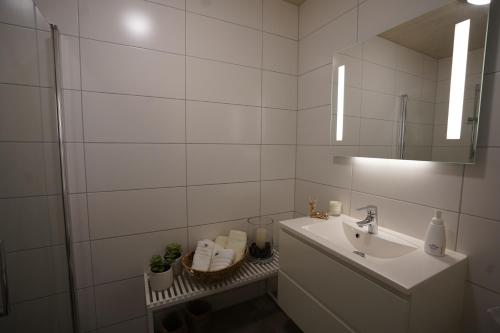 a white bathroom with a sink and a mirror at Fjord View Apartment in Stranda
