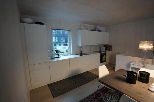 a kitchen with white cabinets and a window at Fjord View Apartment in Stranda