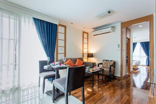 a living room with a table and chairs and a living room at D Varee Montara Thonglor 25 in Bangkok