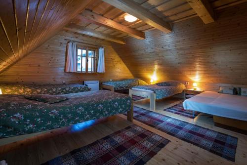 a attic room with three beds and a window at Drevenica Polomka-BBQ-Village center-Traditional design-Close to major attractions in Brezno