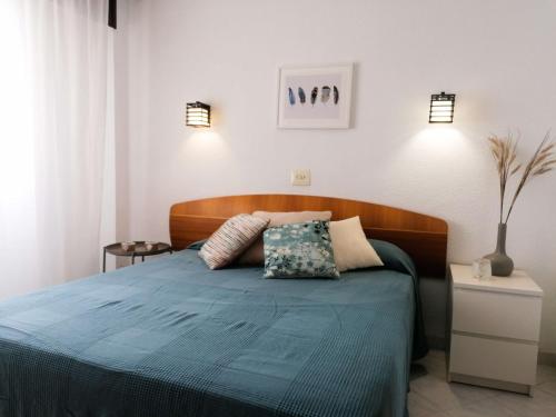 sypialnia z niebieskim łóżkiem z 2 poduszkami w obiekcie EDIFICIO IFACH III w mieście Calpe