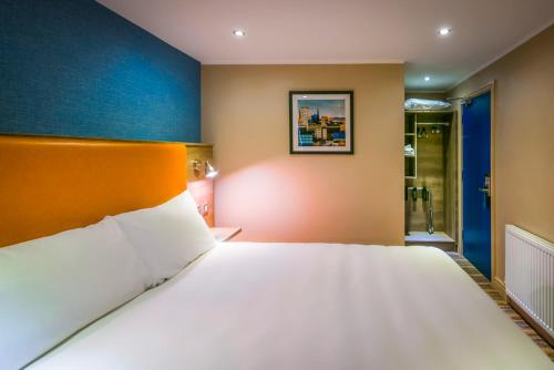 a bedroom with a white bed and white walls at ibis Styles Birmingham Hagley Road in Birmingham