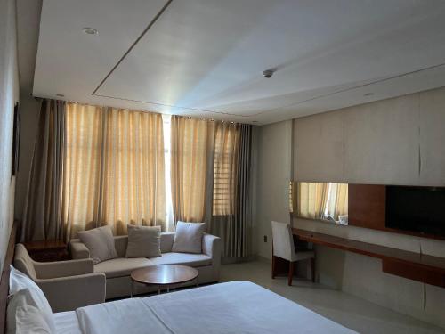 峴港的住宿－Liberty Hotel Đà Nẵng，酒店客房配有床、沙发和电视。