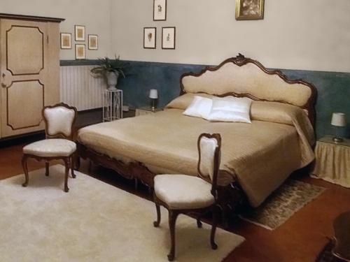 a bedroom with a large bed and two chairs at Casa della Ludo B&B in SantʼAntonino