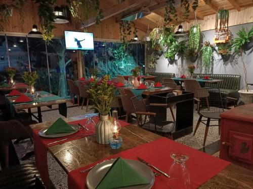 a dining room with tables and chairs and a television at Kartepe Köşkü in Kartepe