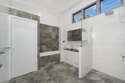 a white bathroom with a sink and a toilet at SEA-Renity on Castle Hill in Townsville
