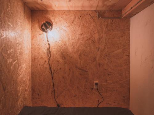una habitación con una pared con una luz en ella en ゲストハウスまたたび en Matsumoto