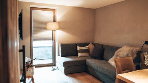 a living room with a couch and a lamp at Mountain See Lodge in See