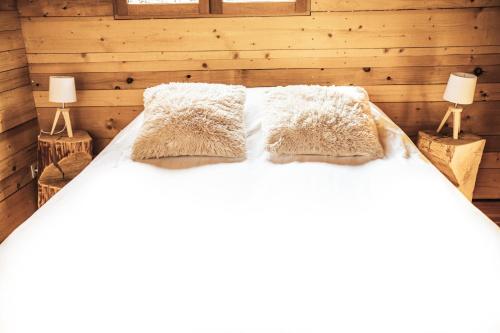 a bedroom with a bed with white sheets and pillows at GITES CURCUMA et COMPAGNIE in Jumencourt