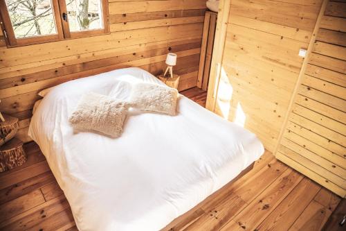 a bedroom with a bed in a wooden room at GITES CURCUMA et COMPAGNIE in Jumencourt