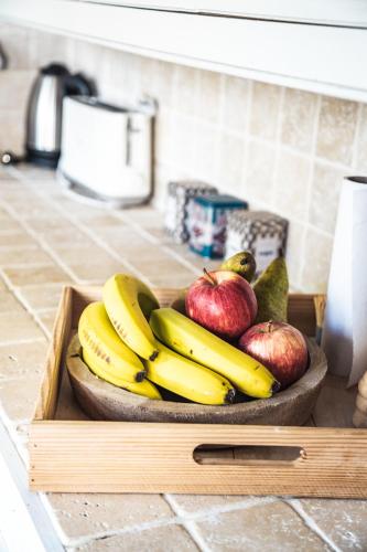 a bowl of bananas apples and pears on a counter at GITES CURCUMA et COMPAGNIE in Jumencourt