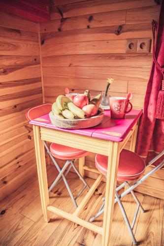 a table with a bowl of fruit on top of it at GITES CURCUMA et COMPAGNIE in Jumencourt