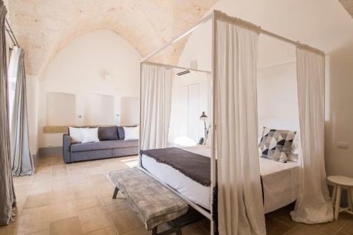 sypialnia z łóżkiem i kanapą w obiekcie Masseria San Giovanni - Epoca Collection w mieście Fasano